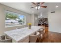 Bright dining room features a large window, ceiling fan, and hardwood floors, perfect for entertaining at 6912 N 19Th St, Phoenix, AZ 85016