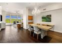 Bright open-concept living room with dining area, hardwood floors, large windows and chandelier at 7275 N Scottsdale Rd # 1001, Paradise Valley, AZ 85253