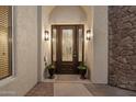 Inviting front entryway featuring stone accents, decorative planters, and a stylish front door at 8817 S 18Th Way, Phoenix, AZ 85042