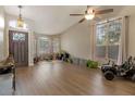 A spacious living room featuring wood floors, large windows, and an arched entry door at 9509 W Tonopah Dr, Peoria, AZ 85382