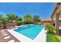 Charming backyard pool with decorative stone accents, complimented by mature trees and landscaping at 9509 W Tonopah Dr, Peoria, AZ 85382
