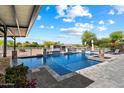 Stunning pool area with a covered patio, tanning chairs, and a horse pasture view at 9722 W Prospector Dr, Queen Creek, AZ 85144