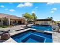 Beautiful pool area with a fountain, covered patio, and lush landscaping at 9722 W Prospector Dr, Queen Creek, AZ 85144