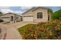Beautiful single-story home with lush landscaping and colorful flowers in front yard at 9834 E Fairview Ave, Mesa, AZ 85208
