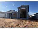 Exterior shot of new construction home featuring a gray exterior, open carport, and minimalist landscaping at 15790 W Cheryl Dr, Waddell, AZ 85355