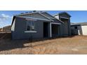 New construction home featuring a gray exterior, open carport, and minimalist landscaping at 15790 W Cheryl Dr, Waddell, AZ 85355
