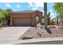 Well-maintained home with a tile roof, desert landscaping, and a two-car garage, offering curb appeal at 11451 E Christmas Cholla Dr, Scottsdale, AZ 85255