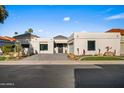 Single-story home with desert landscaping, paved driveway, garage, and black front door at 11977 N 81St St, Scottsdale, AZ 85260
