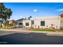 Single-story home with desert landscaping, paved driveway, garage, and black front door at 11977 N 81St St, Scottsdale, AZ 85260
