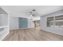 Open living area with hardwood floors, modern fixtures, and ample light with open access to the kitchen at 15825 W Acapulco Ln, Surprise, AZ 85379
