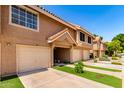 Attractive exterior view of a townhouse featuring a garage, tiled roof, and landscaped surroundings at 1633 E Lakeside Dr # 25, Gilbert, AZ 85234