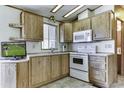 Bright kitchen area features wood cabinets, a white oven, microwave, countertops and sink at 17200 W Bell Rd # 652, Surprise, AZ 85374
