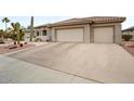 Wide driveway leading up to a beige home with a tile roof and multi-car garage at 20017 N Cielo Ct, Surprise, AZ 85374