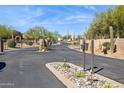 Community entrance showcasing a secure gate and lush desert landscaping at 23520 N 80Th Way, Scottsdale, AZ 85255