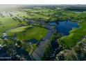 Scenic aerial view of lush golf course with water features and mature trees in a well-maintained community at 247 E Las Puertas Ln, Queen Creek, AZ 85140