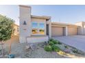 Charming home with well-manicured landscaping, a three-car garage, and a welcoming front entrance at 247 E Las Puertas Ln, Queen Creek, AZ 85140