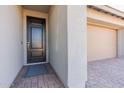 Inviting front entrance with a sleek black door, stylish brick walkway, and access to the garage at 247 E Las Puertas Ln, Queen Creek, AZ 85140