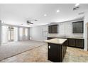 Open kitchen features a center island and dark cabinets at 24868 W Kowalsky Ln, Buckeye, AZ 85326