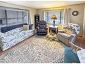 Bright living room with a patterned sofa, recliner chairs, decorative rug, and large windows at 25 S 102Nd St # 73, Mesa, AZ 85208