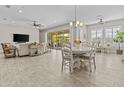 Open-concept living room with tile floors, slider to patio, and a dining area at 30406 N 116Th Ln, Peoria, AZ 85383