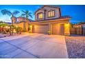 Attractive two-story home with a three-car garage and well-maintained landscaping, illuminated at twilight at 3270 W White Canyon Rd, San Tan Valley, AZ 85144