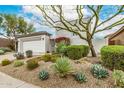 Landscaped front yard featuring native desert plants and a vibrant tree adding curb appeal at 32771 N 70Th St, Scottsdale, AZ 85266