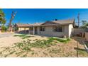 Side view of a single story home with tan paint, desert landscaping, and secure window bars at 339 E 9Th Dr, Mesa, AZ 85210