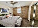 Comfortable main bedroom with a brick accent wall and ample closet space at 3737 E Turney Ave # 223, Phoenix, AZ 85018