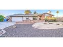 Charming single story home featuring a spacious driveway, two-car garage, and brick accents at 3906 W Aire Libre Ave, Phoenix, AZ 85053