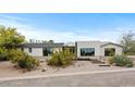 Attractive single-story home with minimalist desert landscaping, enhancing curb appeal and modern design elements at 4035 E Mcdonald Dr, Phoenix, AZ 85018