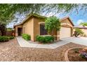 Beautiful desert home featuring a two-car garage, a walkway, and green shrubbery at 4140 E Sundance Ave, Gilbert, AZ 85297