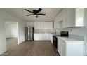 Bright kitchen featuring white cabinets, stainless steel appliances, and light wood floors at 8125 E 5Th Ave, Mesa, AZ 85208