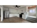 Bright kitchen featuring white cabinets, stainless steel appliances, and light wood floors at 8125 E 5Th Ave, Mesa, AZ 85208