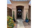 Inviting front entry with arched doorway, double doors, and manicured landscaping at 9059 E Butherus Dr, Scottsdale, AZ 85260