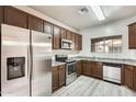 Well-lit kitchen featuring wood cabinets, stainless steel appliances, and gray countertops at 9435 S 33Rd Dr, Laveen, AZ 85339