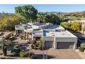 Stunning home exterior with desert landscaping, a circular driveway, and a two-car garage at 9726 E Hidden Green Dr, Scottsdale, AZ 85262