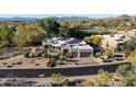 Beautiful home with desert landscaping, a circular driveway, and mountain views in the background at 9726 E Hidden Green Dr, Scottsdale, AZ 85262