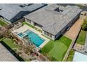 Aerial view showcasing a backyard oasis with pool, putting green and landscaped yard at 9903 E Rotation Dr, Mesa, AZ 85212