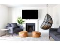 Bright living room features fireplace, mounted television, and hanging chair at 3907 E Marilyn Rd, Phoenix, AZ 85032
