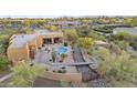 Expansive aerial view showcases the desert home, pool, and meticulously landscaped grounds at 8625 E Camino Vivaz --, Scottsdale, AZ 85255