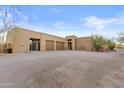 Exterior shot showcasing the desert home and circular driveway with desert landscaping at 8625 E Camino Vivaz --, Scottsdale, AZ 85255
