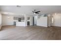 Spacious open floor plan with lots of light and wood floors, seamlessly connects to the kitchen with gray cabinets at 1096 E Rolls E Rd, San Tan Valley, AZ 85143