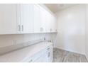 Practical laundry room with white cabinetry, plenty of counter space, and space for washer and dryer at 14429 N 75Th Dr, Peoria, AZ 85381