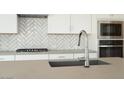 Close-up of the kitchen sink featuring modern fixtures and stainless steel appliances at 1571 E Tiffany Way, Gilbert, AZ 85298