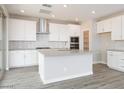 Modern kitchen with white cabinetry, stainless steel appliances, and stylish backsplash at 1571 E Tiffany Way, Gilbert, AZ 85298