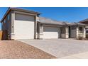 Spacious three-car garage with a paved driveway and well maintained landscaping at 1644 E Joelle Dr, Casa Grande, AZ 85122
