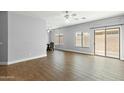 Open-concept living room with wood-look flooring, natural light, ceiling fans, and sliding glass door access at 1650 S Crismon Rd # 6, Mesa, AZ 85209