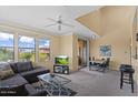 Bright living room with a modern gray sofa, a ceiling fan, and a large window with picturesque views at 20100 N 78Th Pl # 2203, Scottsdale, AZ 85255