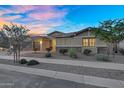 Inviting home with manicured landscaping, desert shrubs, a brick driveway, and a spacious three-car garage at 22884 E Via De Olivos --, Queen Creek, AZ 85142