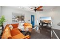Modern living room featuring a stylish orange sectional couch, dark floors and white walls for a clean, bright space at 2511 E Pinchot Ave, Phoenix, AZ 85016